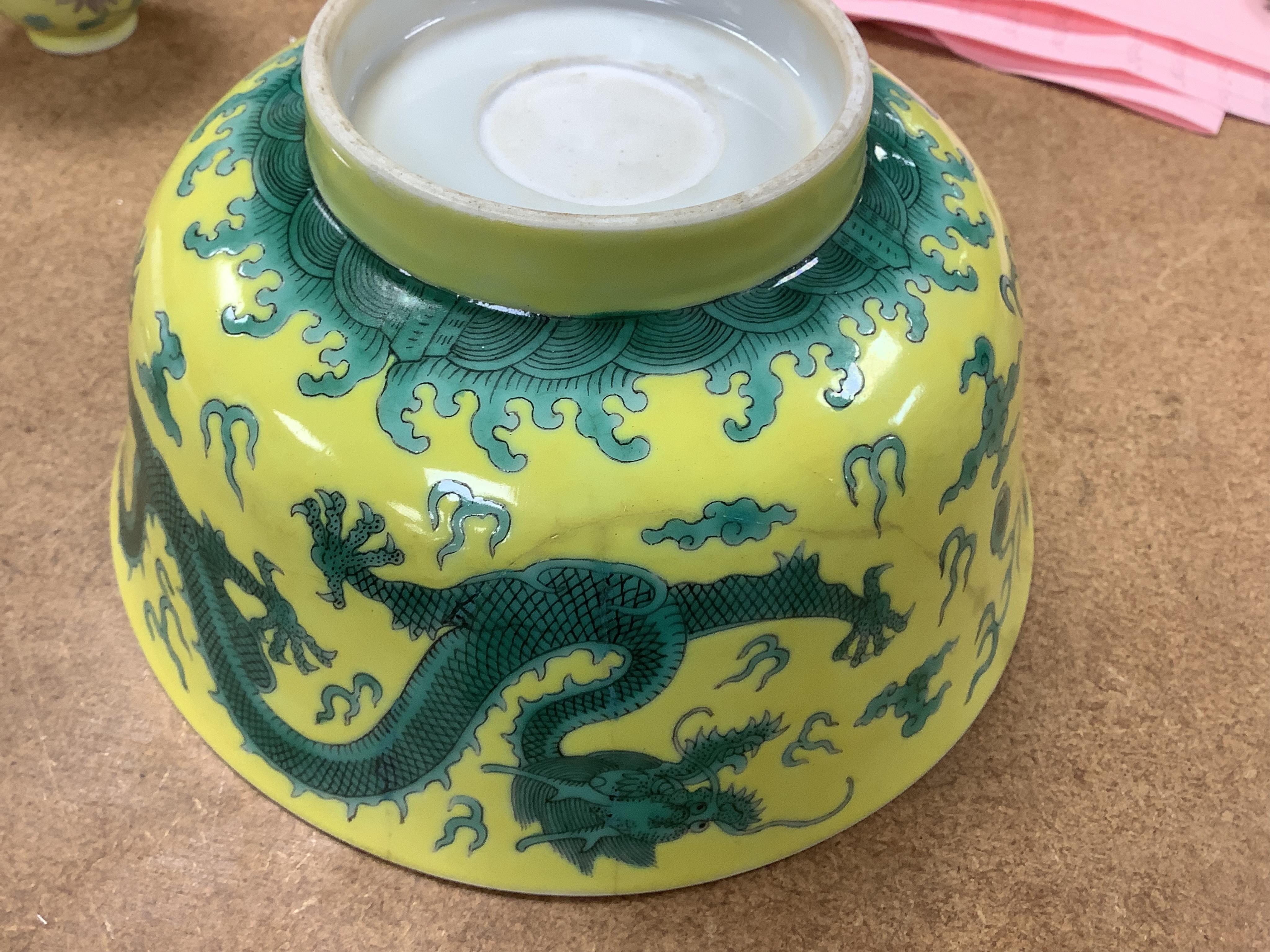 A Chinese yellow ground 'dragon' bowl, probably late Qing dynasty, and a similar floral cup, bowl 9cm high, 18.5cm diameter. Condition - bowl has a large section restored